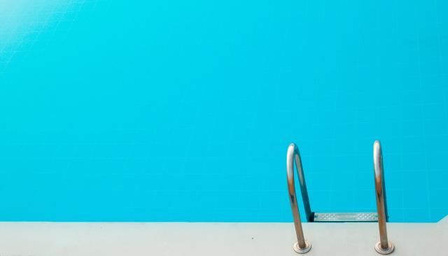 Poolleiter in einem türkisfarbenem Pool